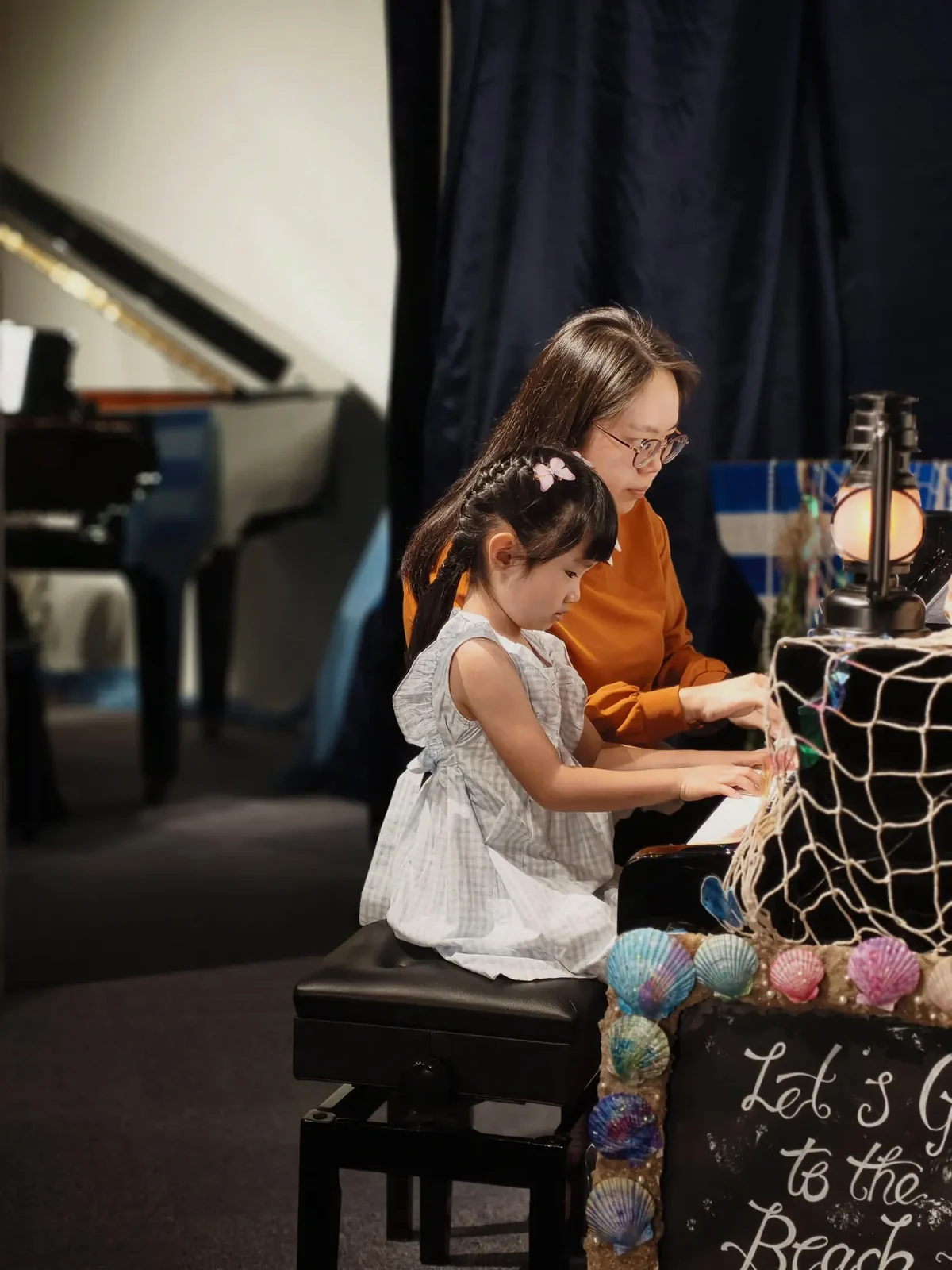 Young FingerGYM graduate playing piano during her first performance