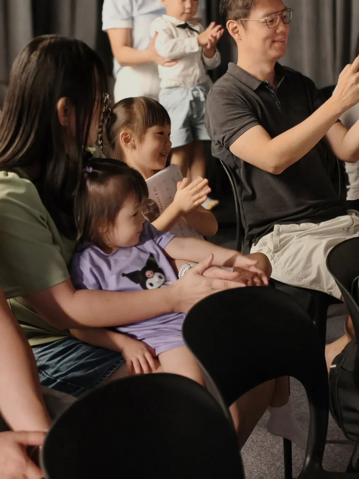 Parents and children sharing a proud audience moment at the graduation performance