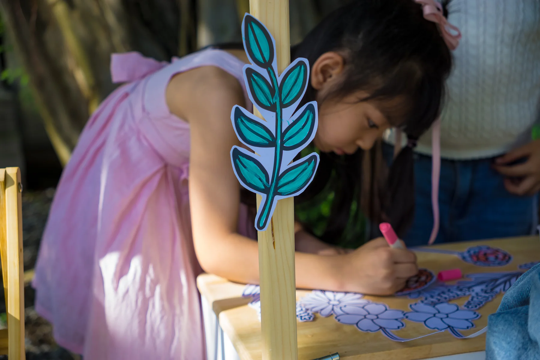 Child colouring an activity sheet at an Expressivo community event
