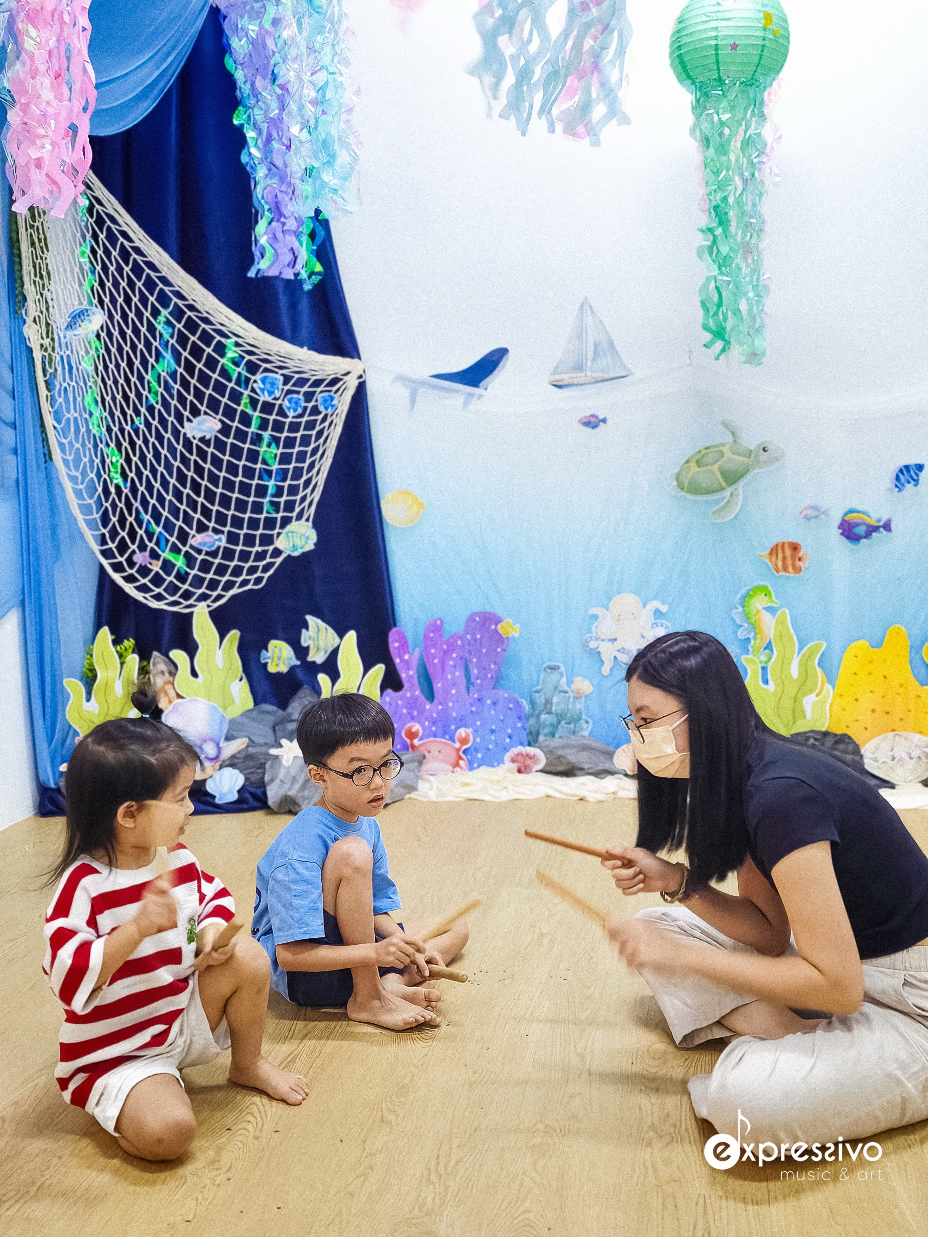 Young musicians exploring rhythm with drums at the beach-themed workshop