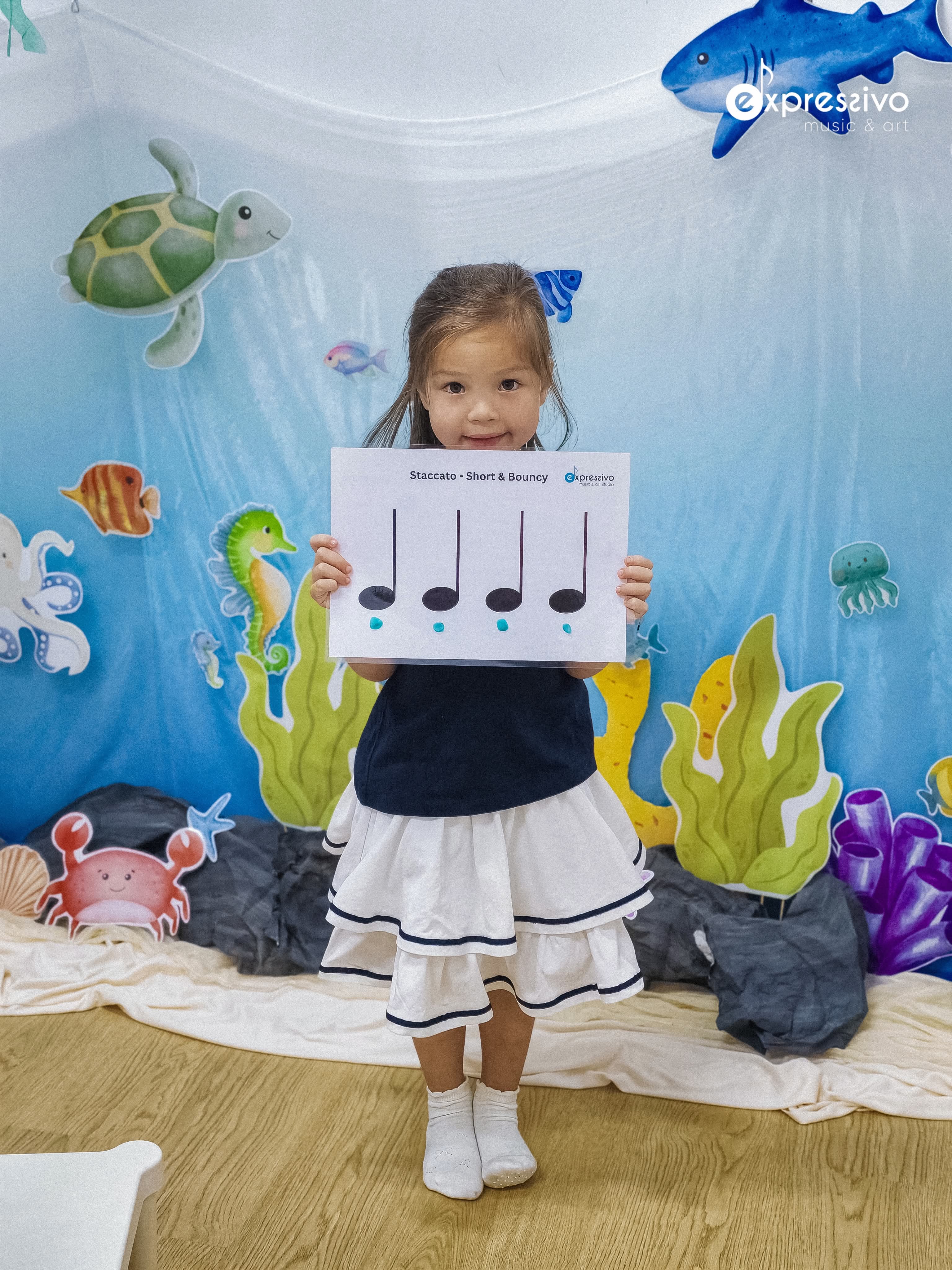 Young musician showing a staccato music learning card