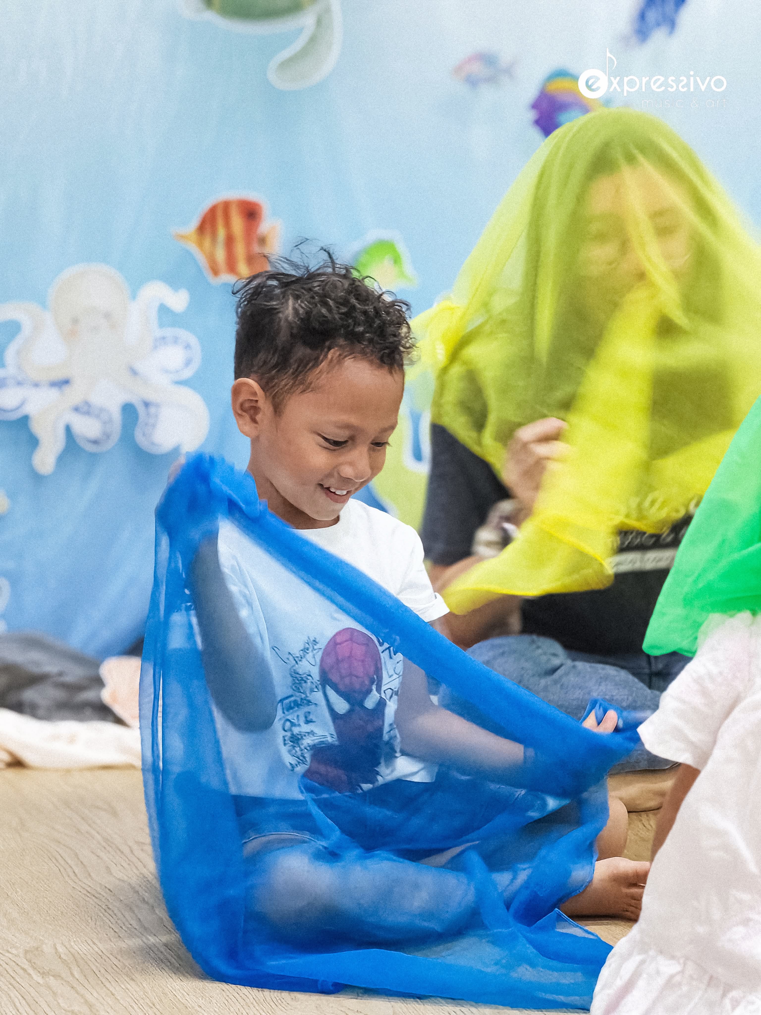 Young musician exploring movement and blue sensory scarves