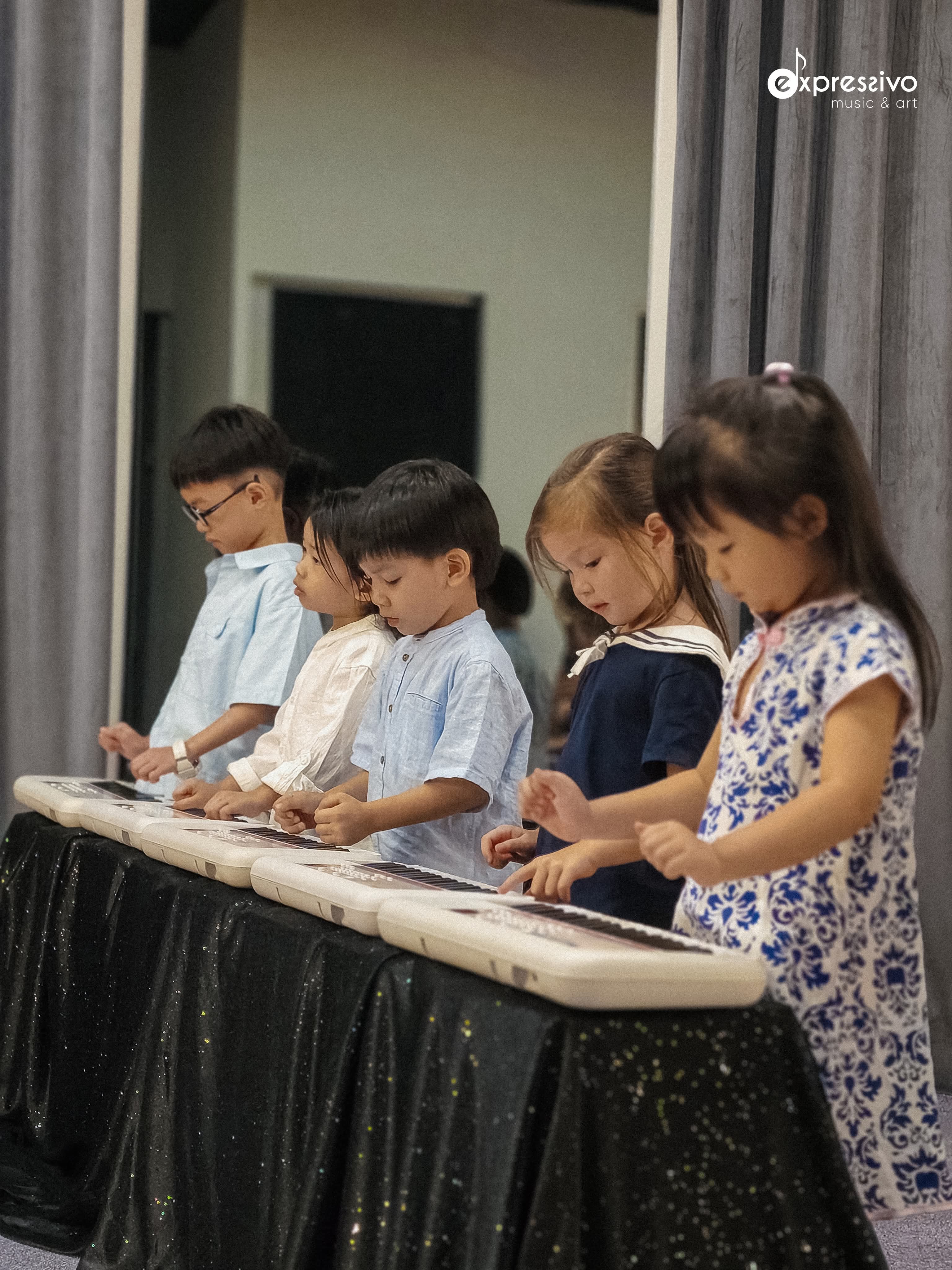 Children performing a keyboard ensemble for their families