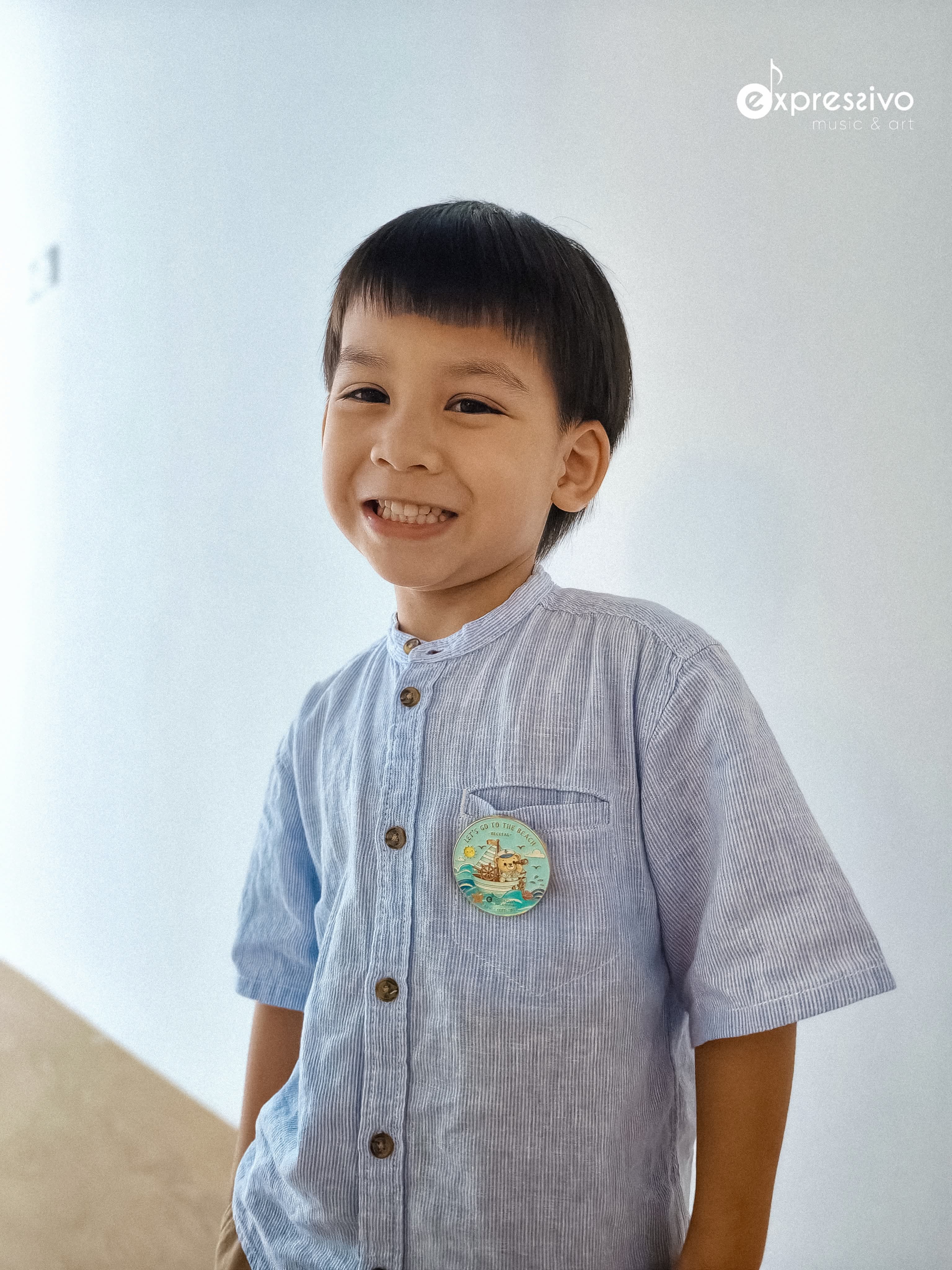 Young musician proudly wearing a Let’s Go To The Beach workshop keepsake