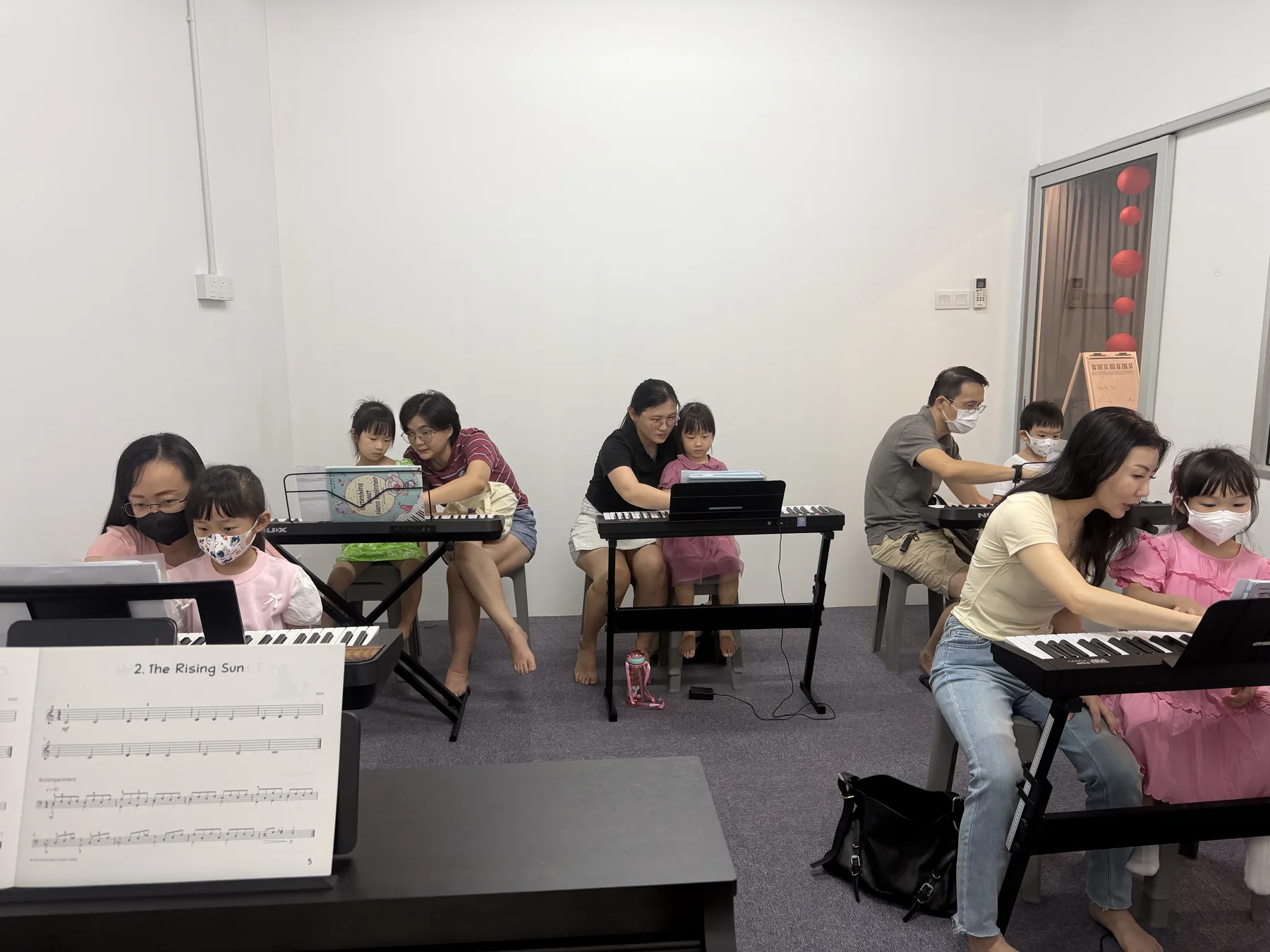 Children and teachers taking part in a group keyboard class at Expressivo