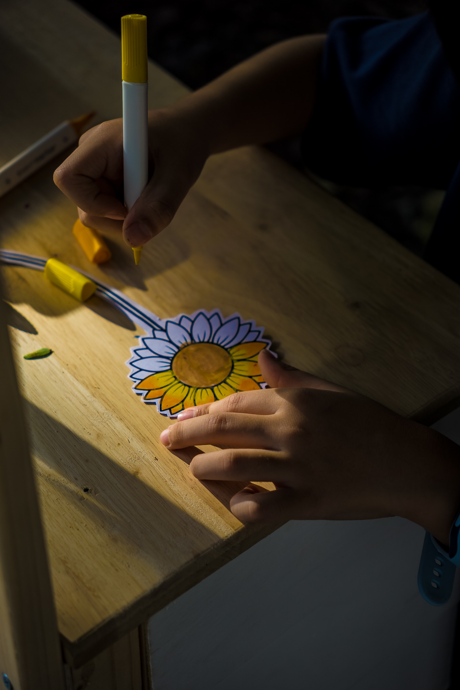 Child colouring a sunflower at the flower art station